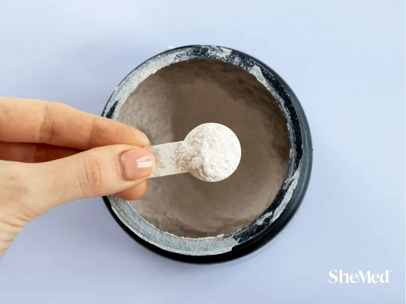 A close-up of a scoop filled with bright electrolyte powder, ready to be mixed with water for hydration