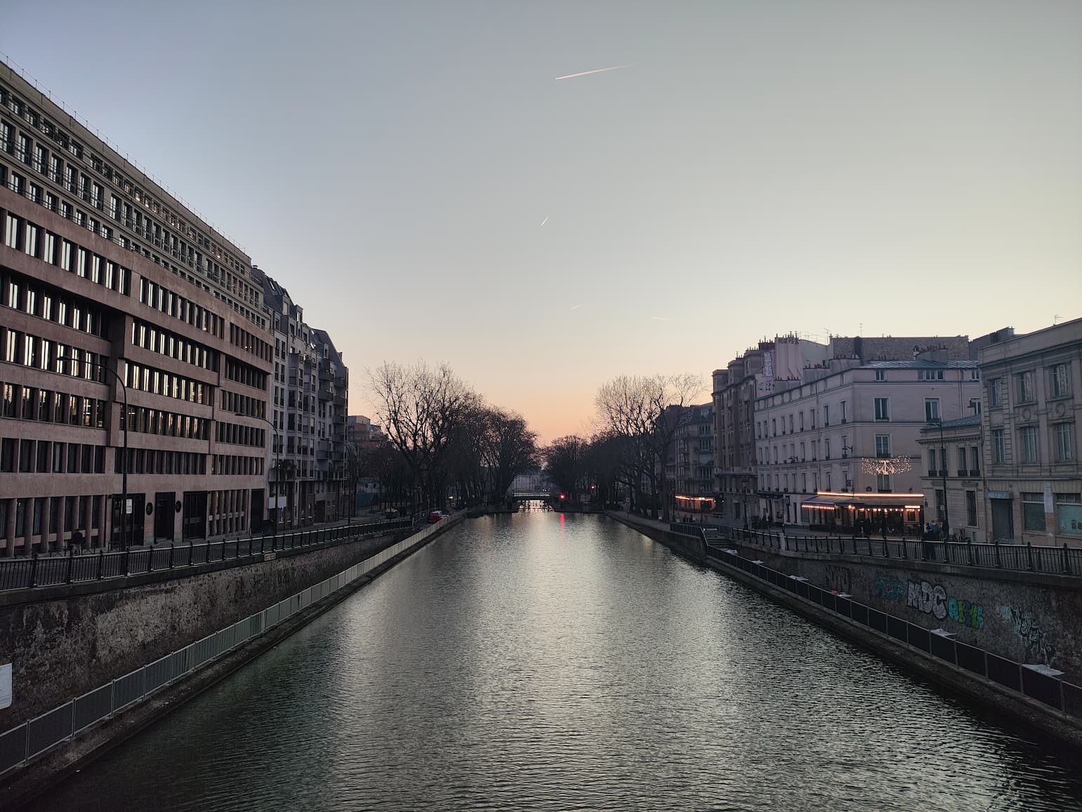 Le canal Saint-Martin entre deux quais de Paris au crépuscule.