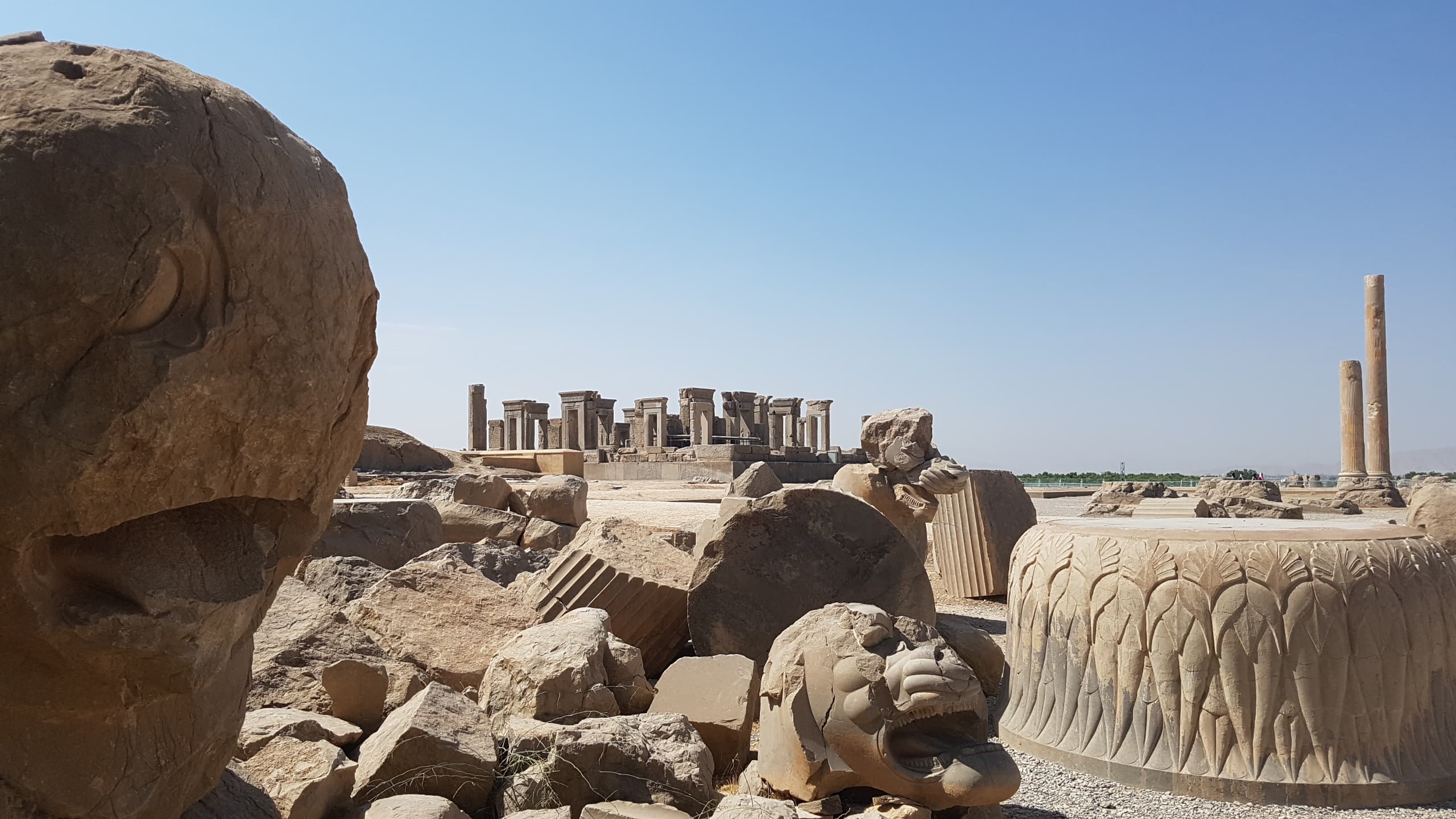 Vestiges sculptés et colonnes de Persépolis sous le ciel bleu, en Iran