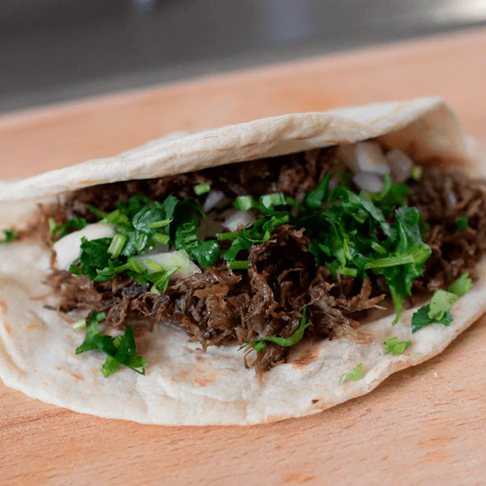 Barbacoa taco with onion and coriander