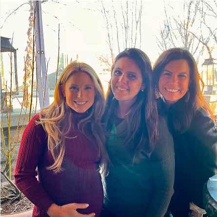 Group photo of three IFI colleagues—one pregnant—during an outdoor team gathering.