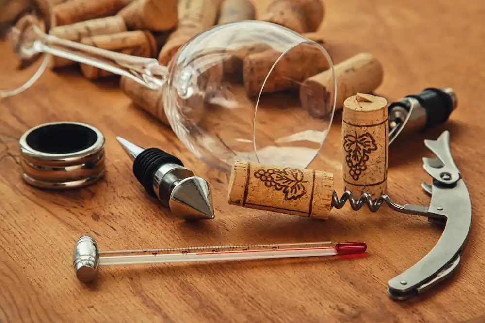 wine corkscrew, corks and empty wine glass
