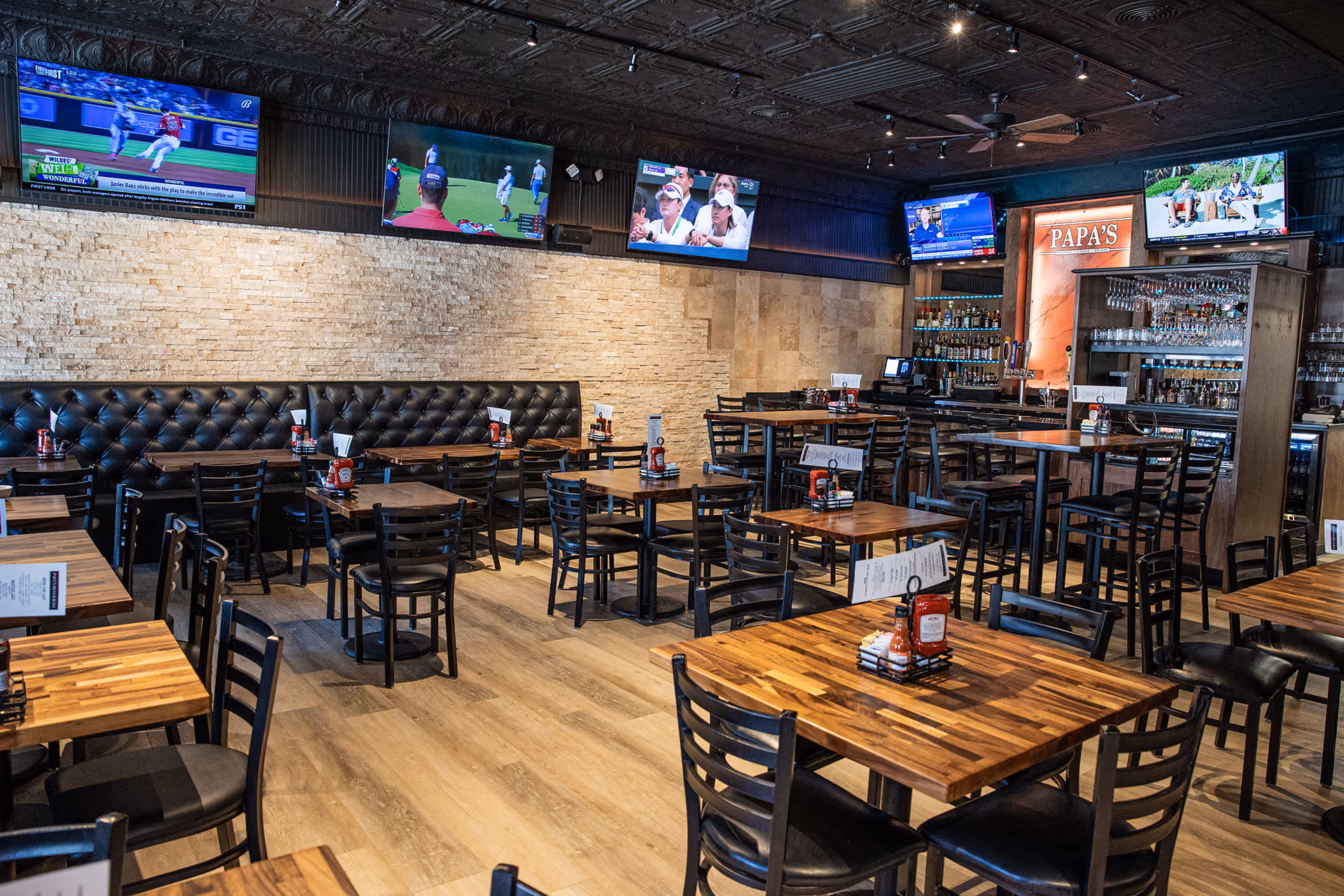 A restaurant with a bar and a large screen TV.