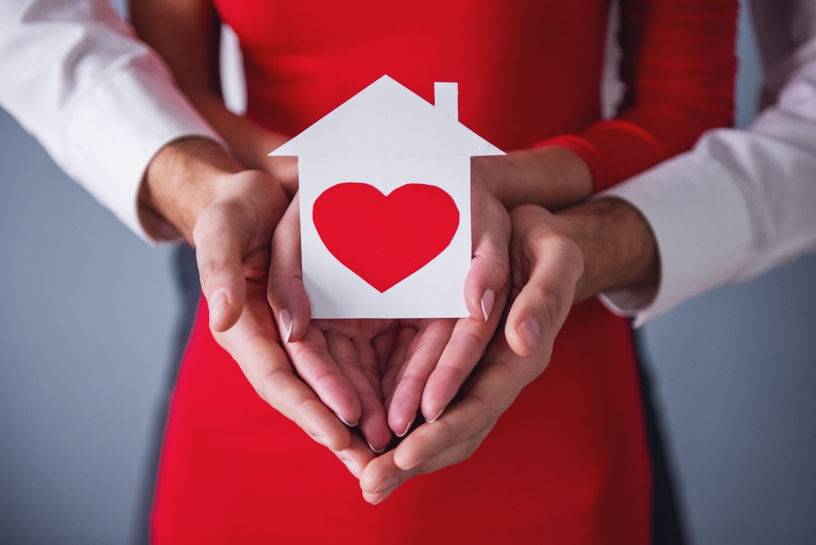 Loving couple holding a drawing of a home in their hands, practicing preventive home maintenance