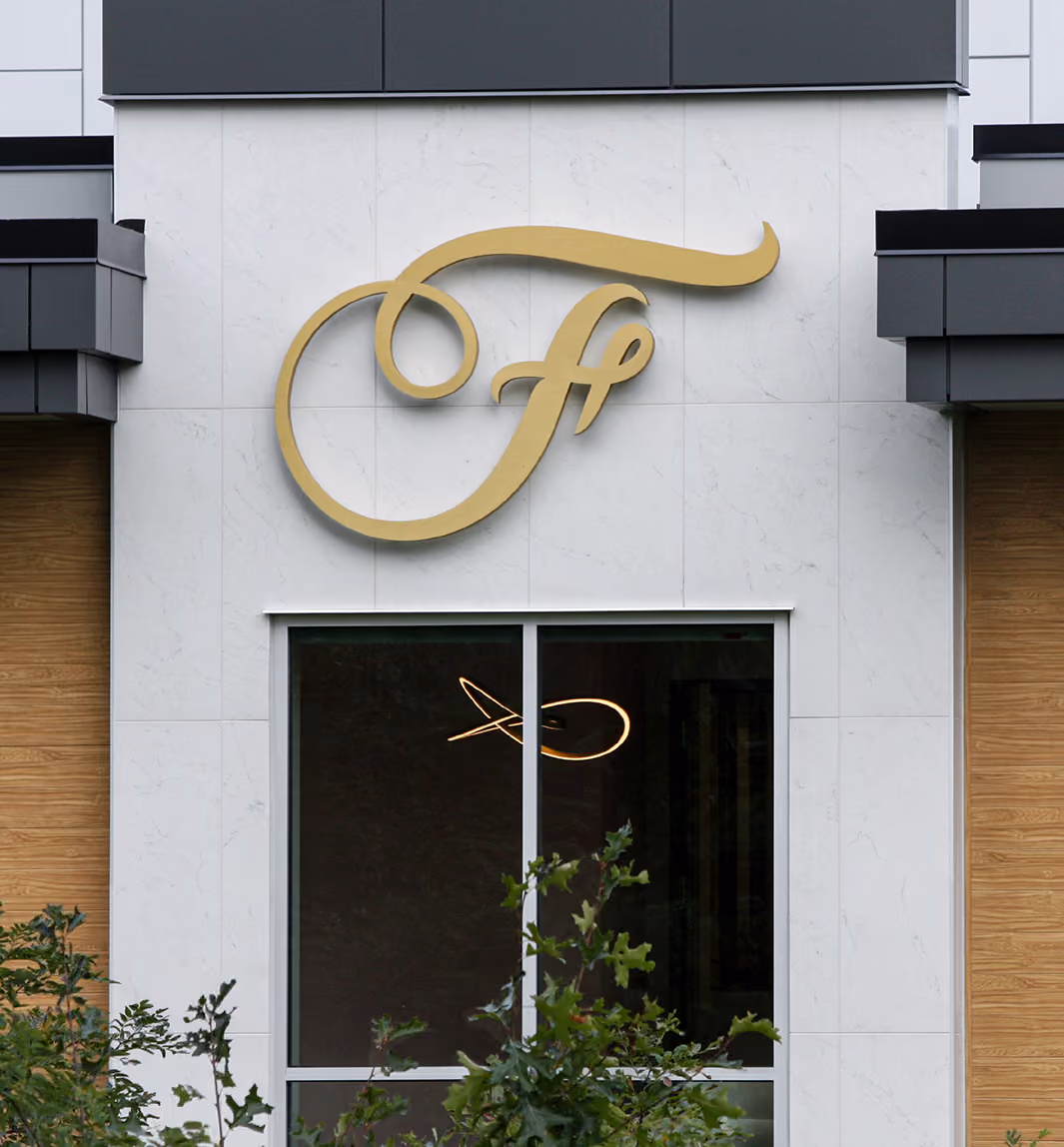 Frattallone Wealth Partners gold logo on the exterior of the office building.