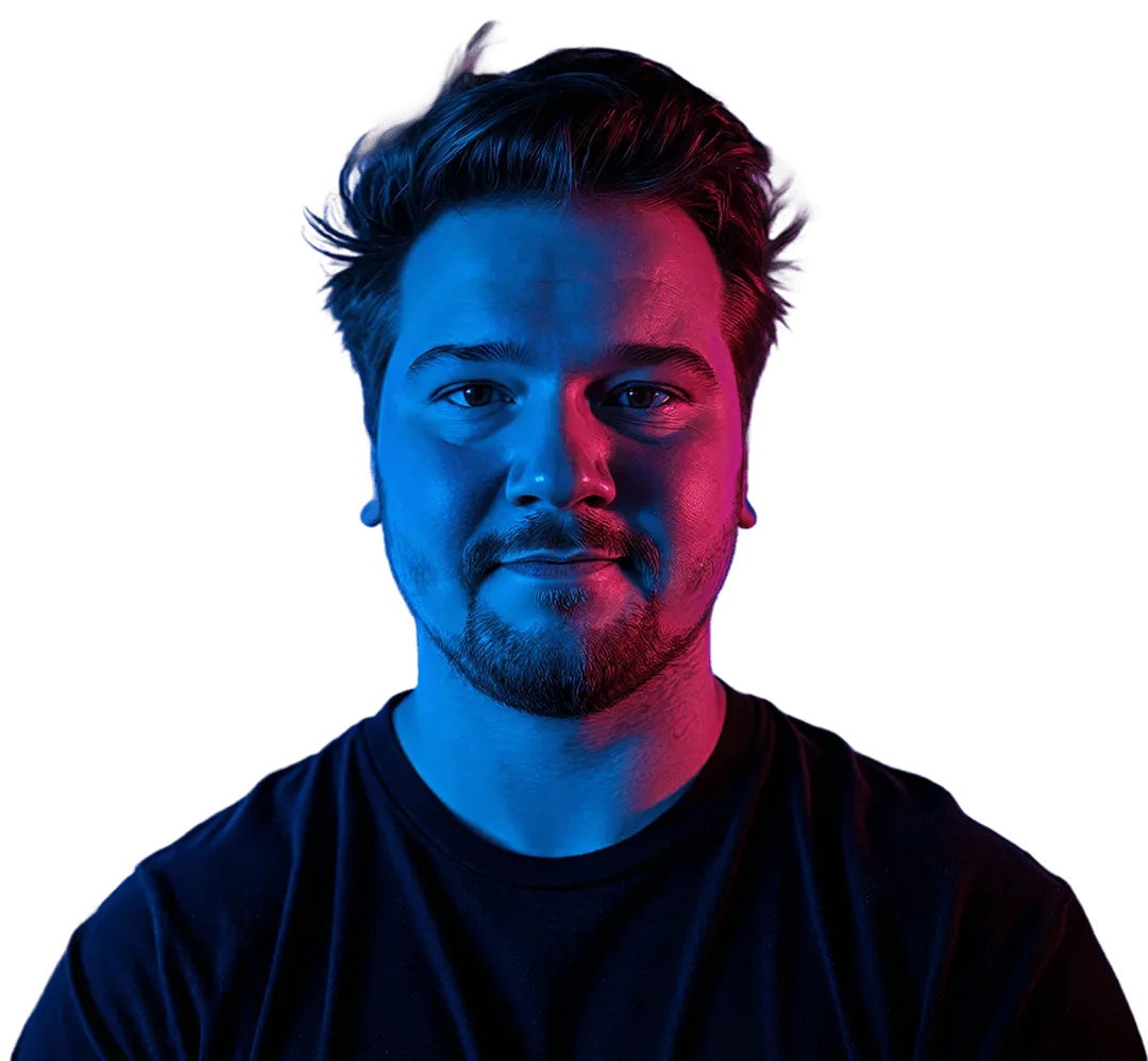 Man with beard and mustache lit by blue light on left and pink light on right, against dark background.