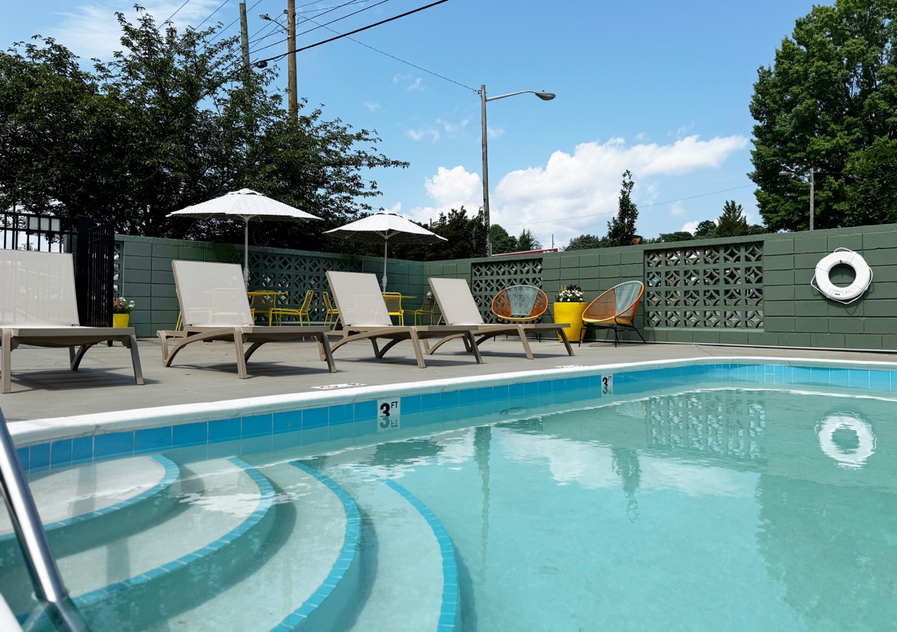 Outdoor pool area with privacy fence and lounge chairs