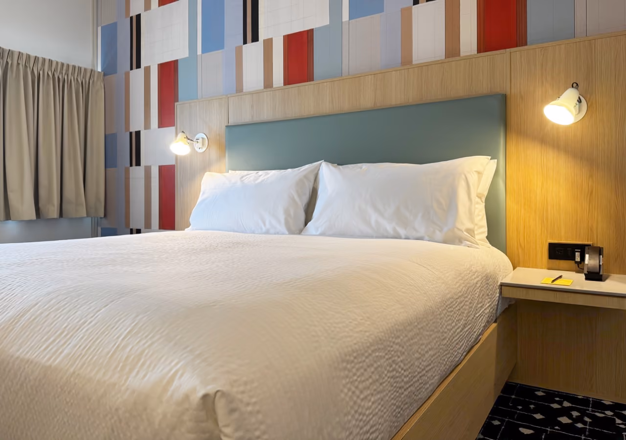 King size bedroom with colorful wall texture behind bed