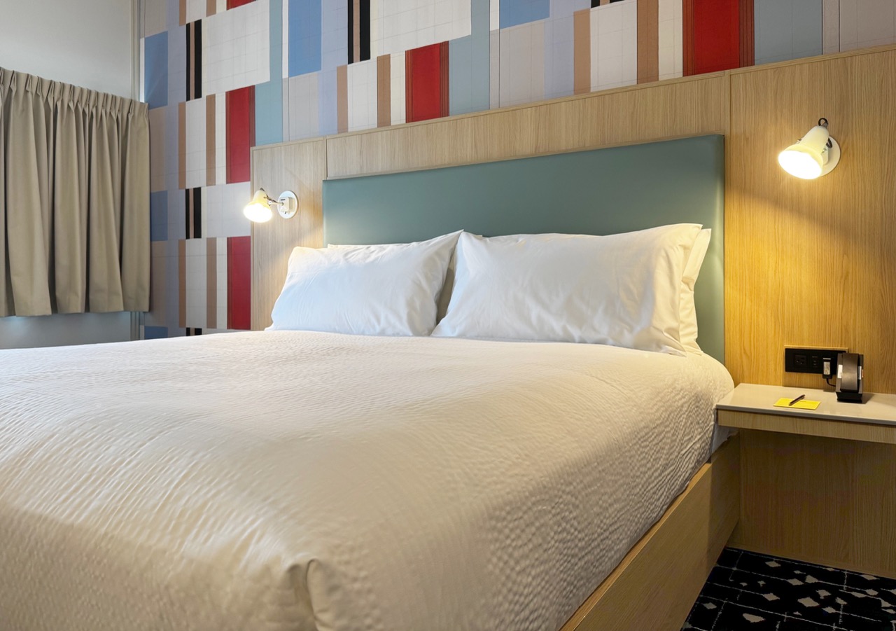 King size bedroom with colorful wall texture behind bed