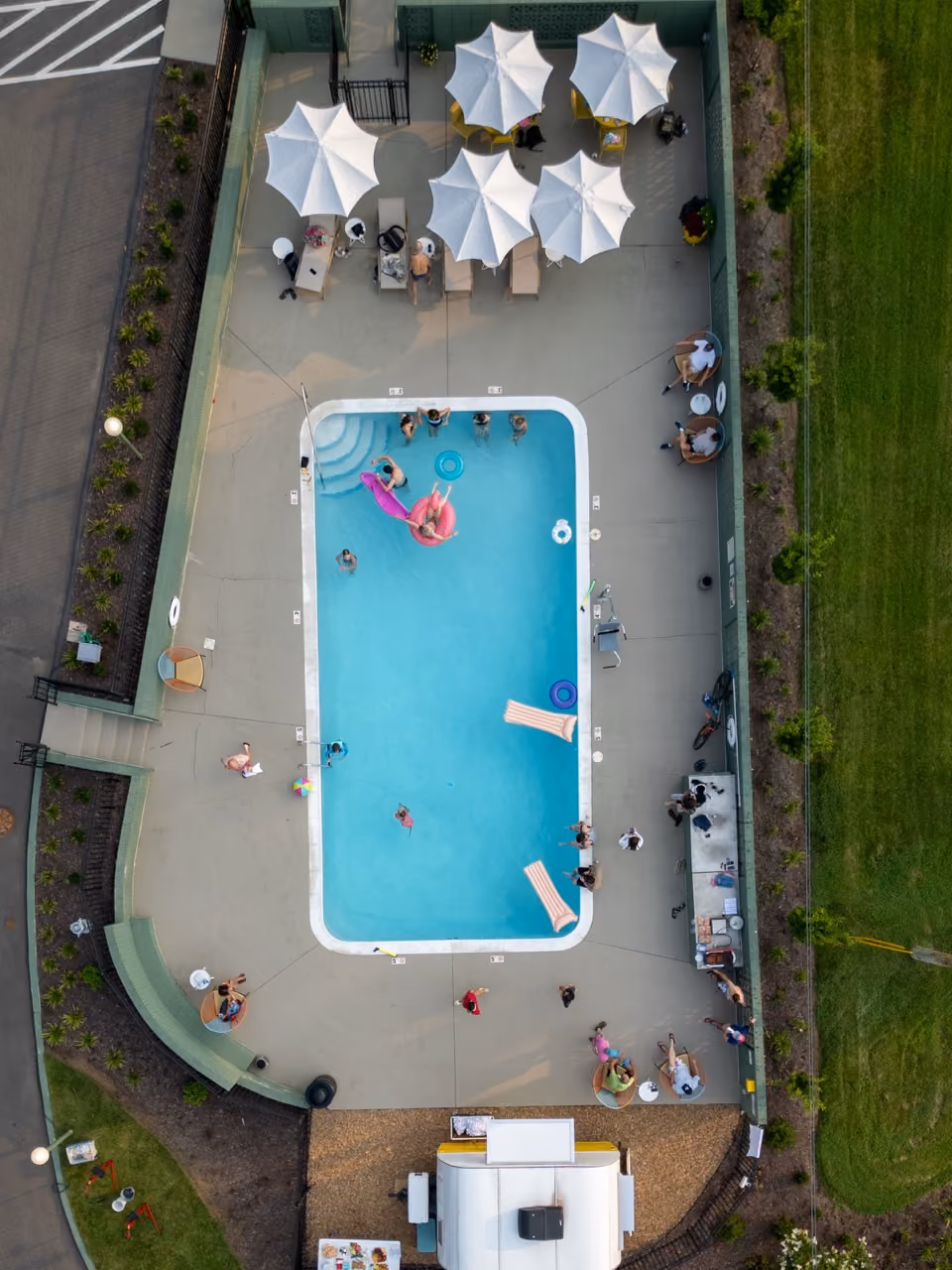 Overhead shot of outdoor pool with umbrellas and loungers nearby