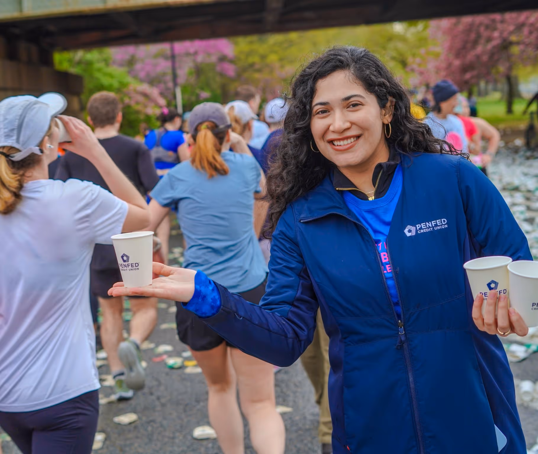 Female PenFed worker at an event holding out a cup