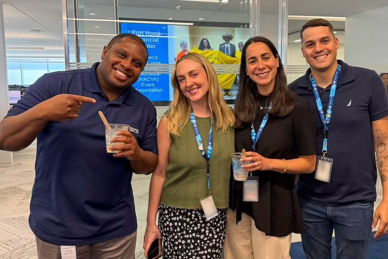 Diverse group of PenFed workers smiling for the camera in the office