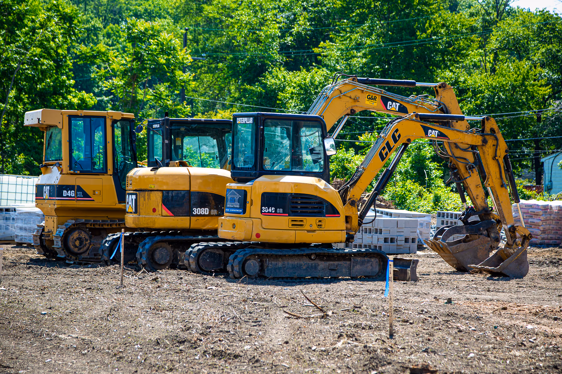 Image of three construction tractors parked next to each other.