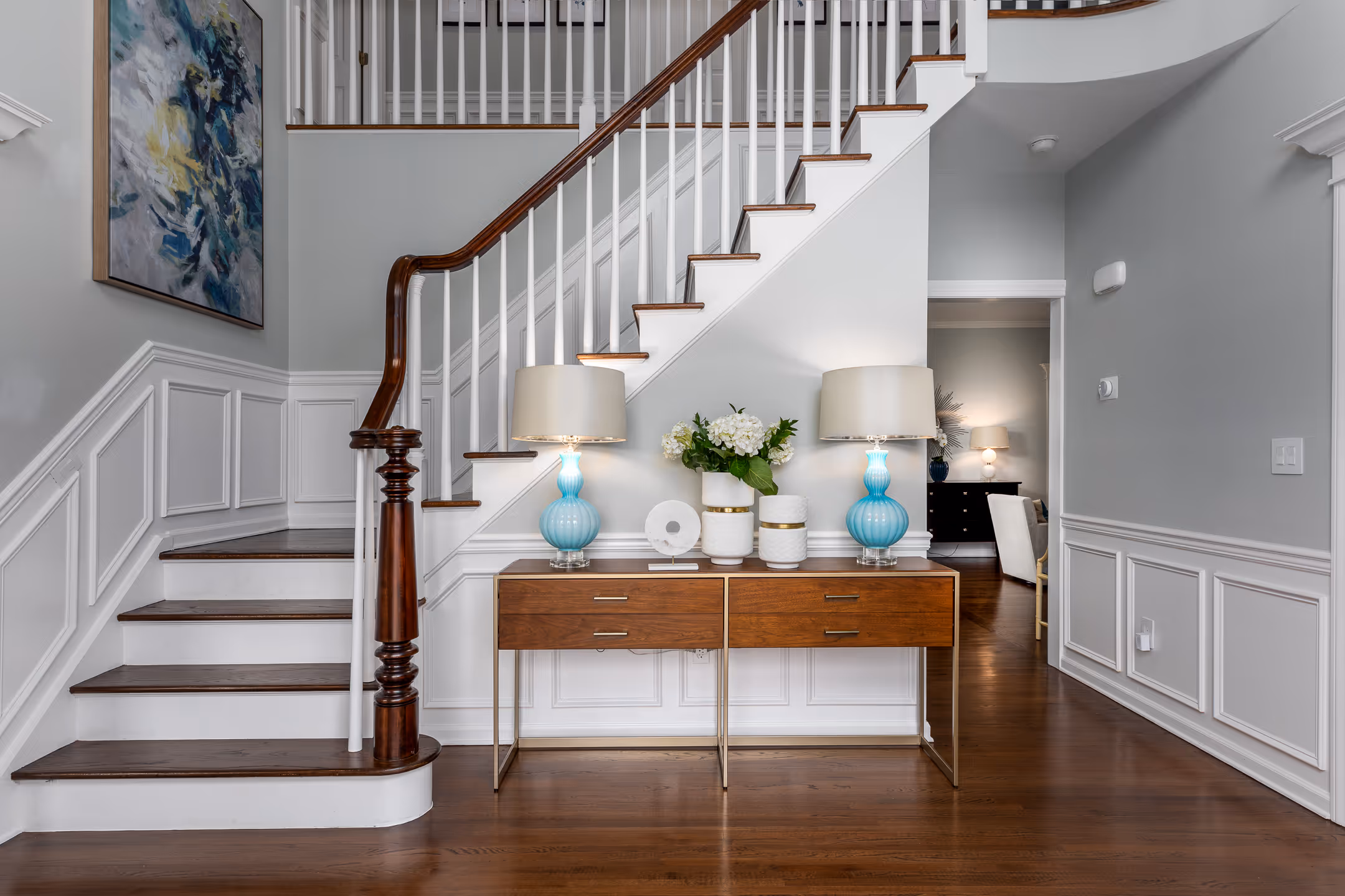 A real estate image of a home entrance with a beautiful stair case.