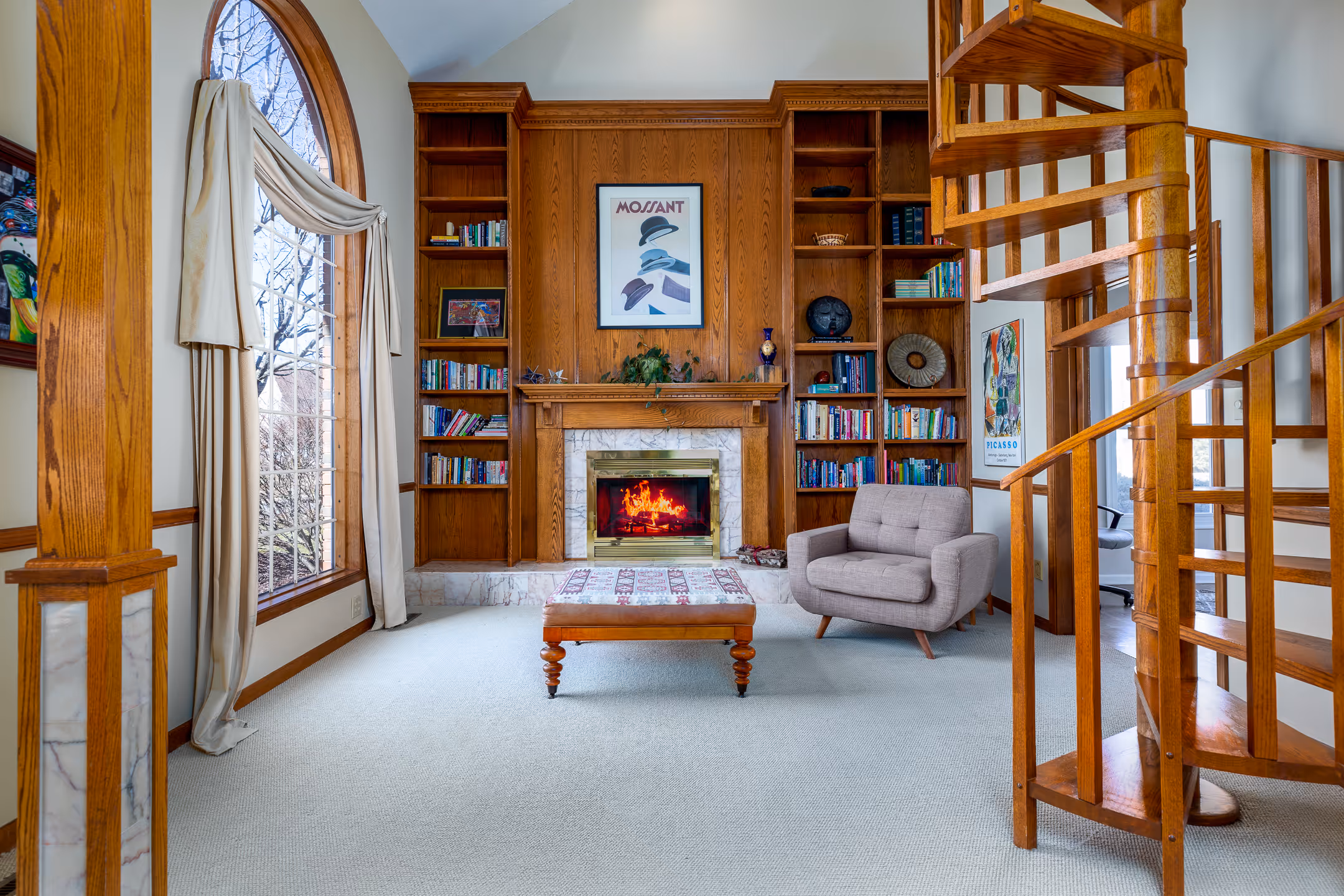 Real estate image of a study with a spiral stair case.