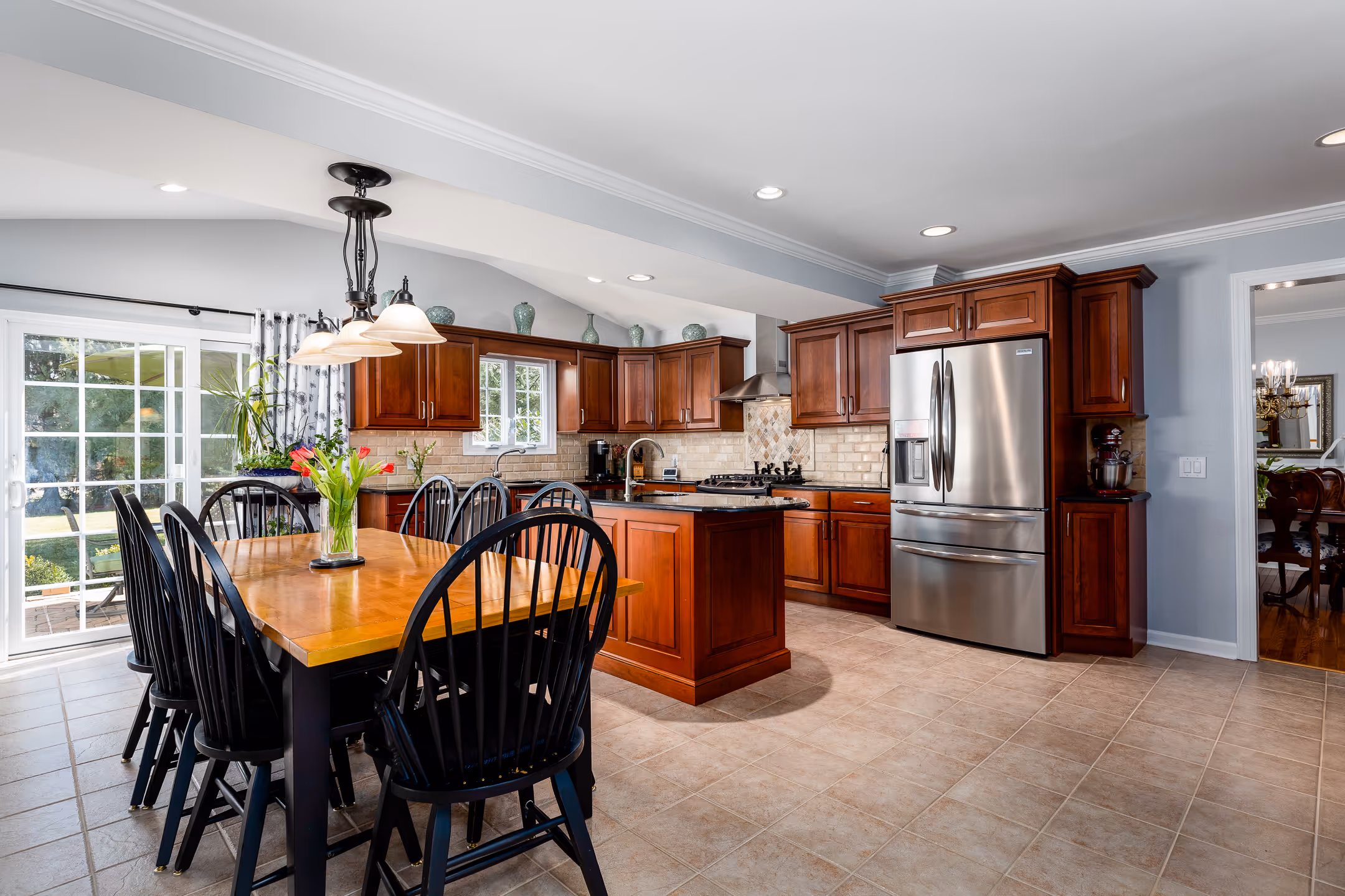 A real estate image of a dinette area in the foreground of a beautiful kitchen.