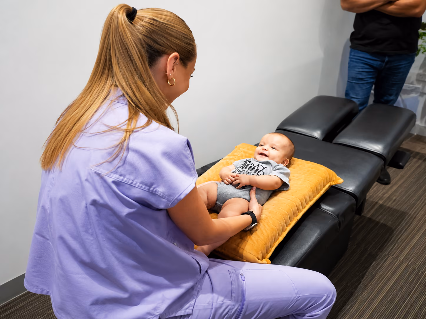 Dr. Mikayla performing a pediatric chiropractic assessment with a baby
