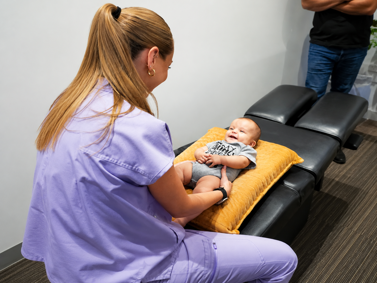 Dr. Mikayla performing a pediatric chiropractic assessment with a baby