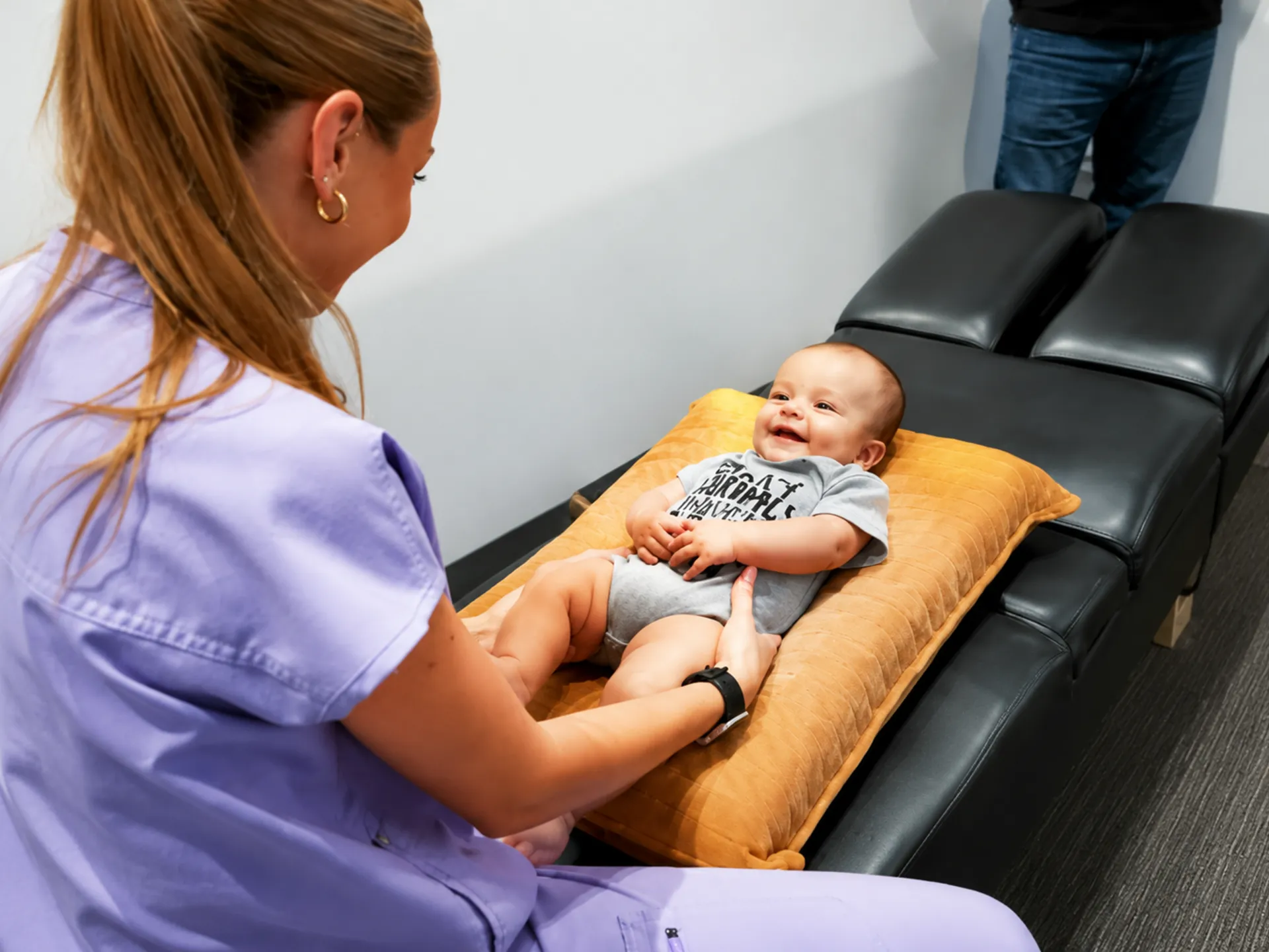 Dr. Mikala Hiben gently assessing an infant during a first pediatric chiropractic visit.