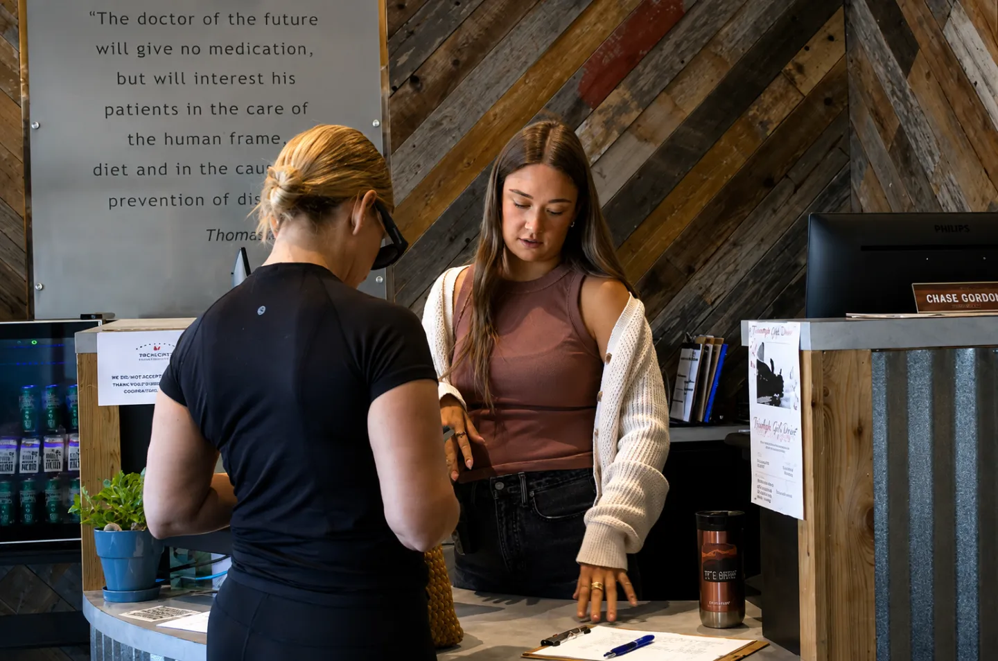 Patient speaking with a receptionist at the Elite Wellness Chiropractic front desk