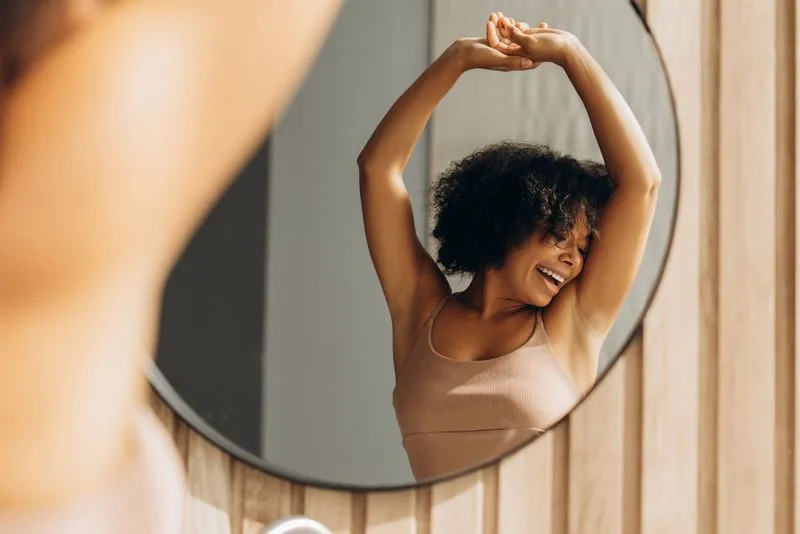 A woman standing in front of a mirror.