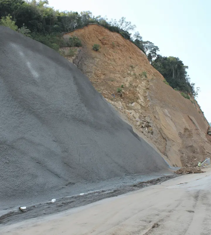 Talud con estabilización: lado derecho natural y lado izquierdo cubierto con malla o concreto proyectado.