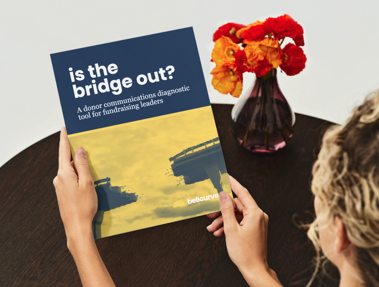 Bonar Bell sitting next to a smiling child in a pink shirt and knee pads on a red concrete bench in Zambia.