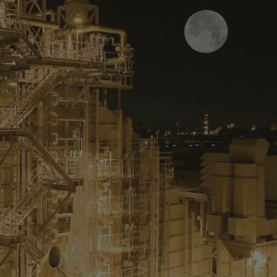 Industrial refinery complex at night with full moon in dark sky