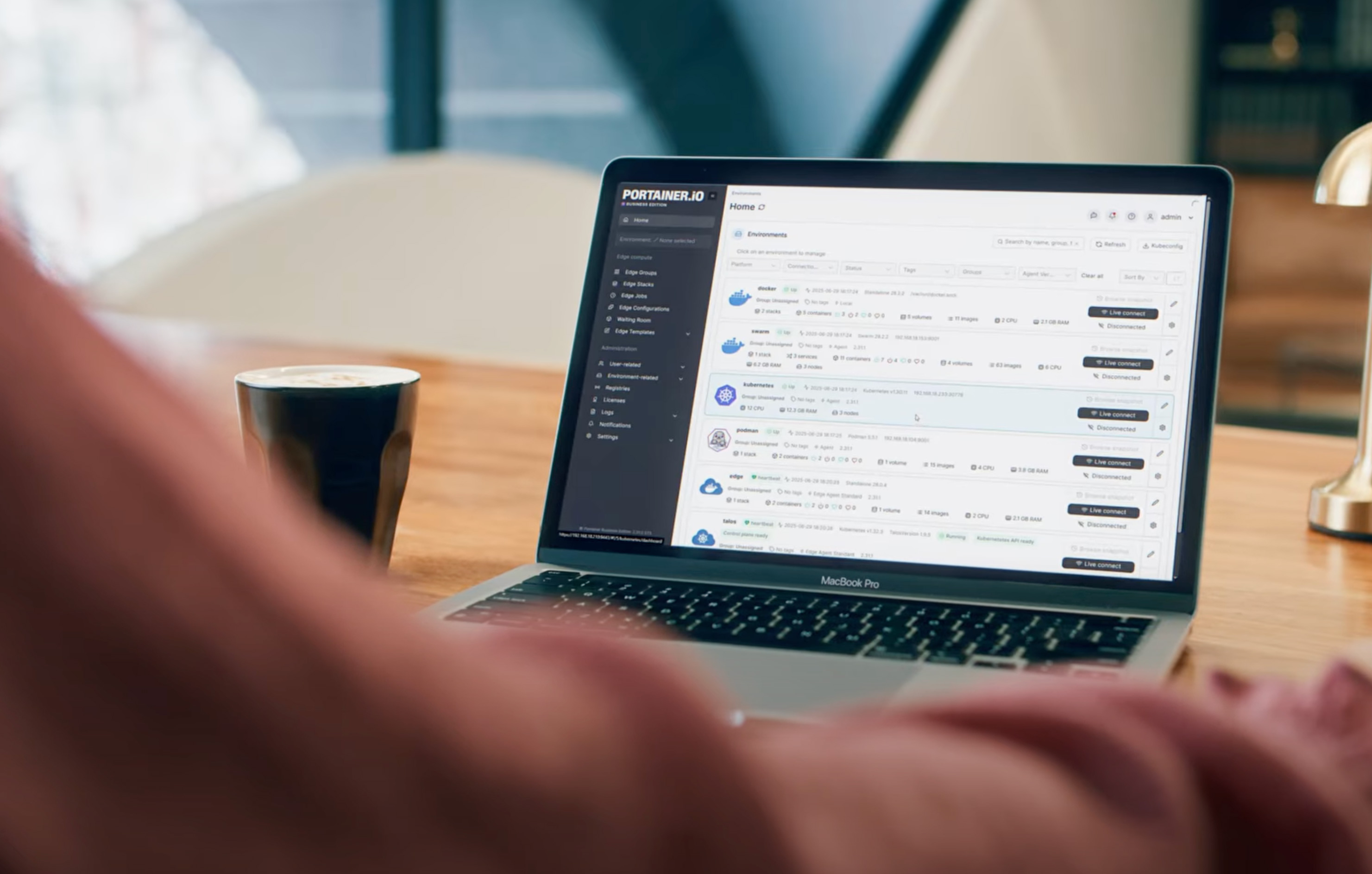 Portainer.io dashboard on MacBook Pro with coffee cup nearby