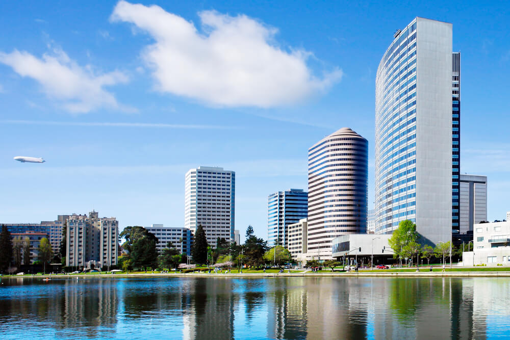 A city skyline with large white buildings near a lake