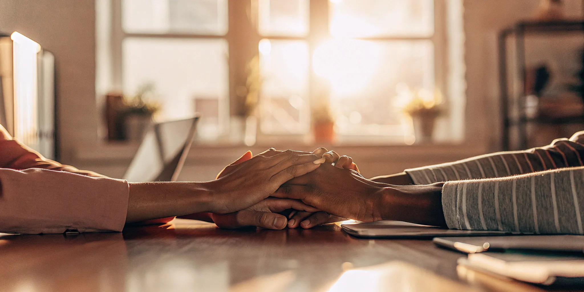 Small business team joining hands, representing group health insurance benefits.