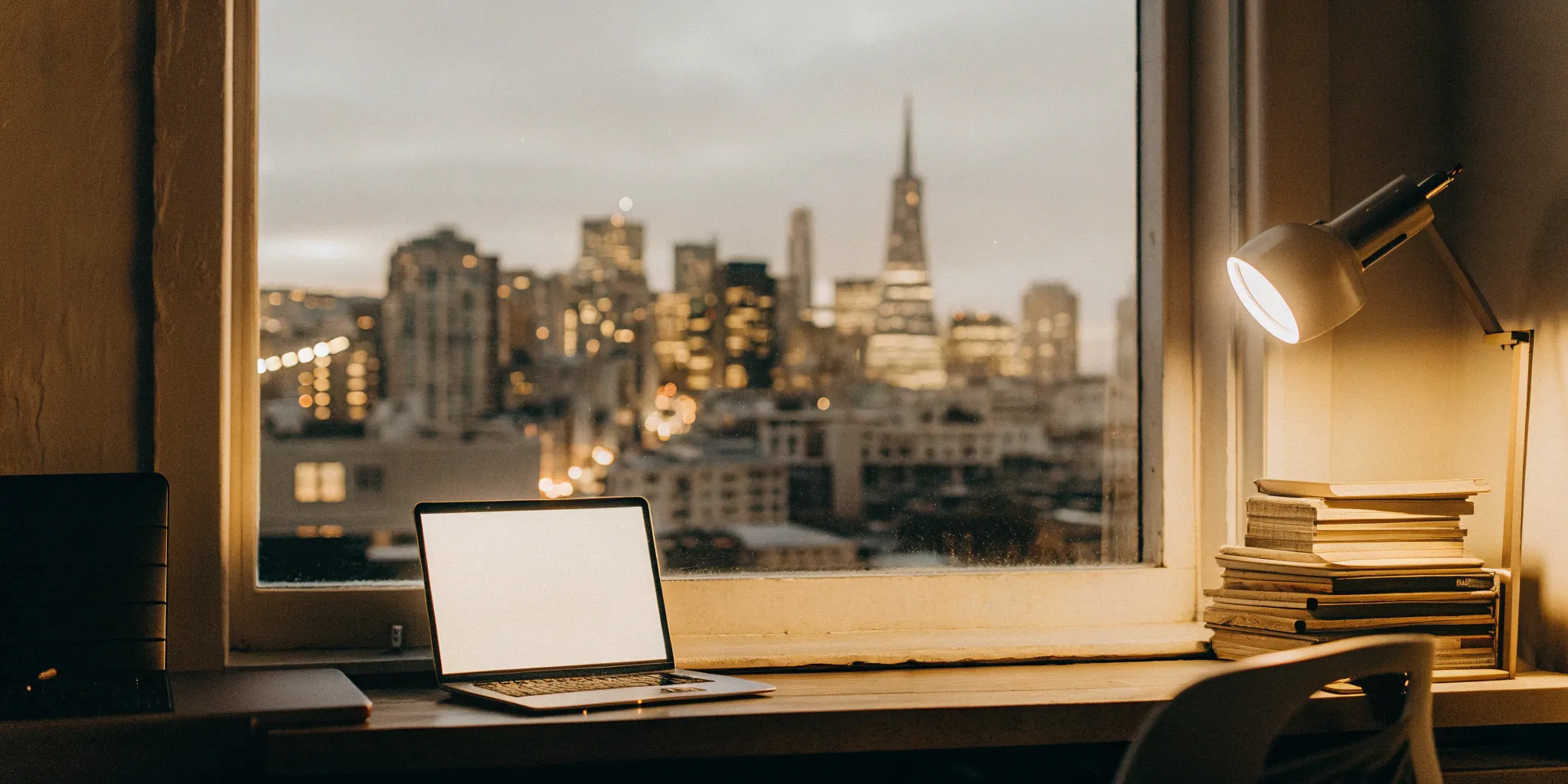 Laptop and books on a desk for learning how to choose a PEO.