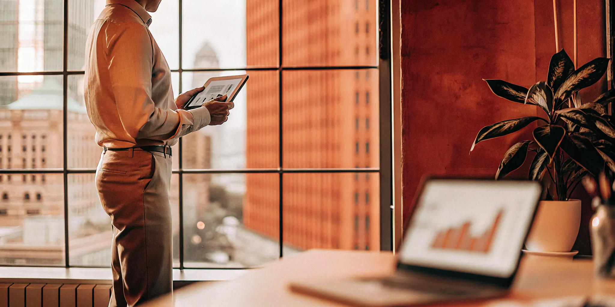 Business professional reviewing the benefits of using a PEO for employees on a tablet in a modern office.