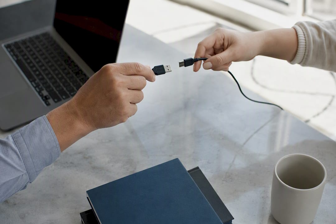 Hands connecting data cable symbolizing integration