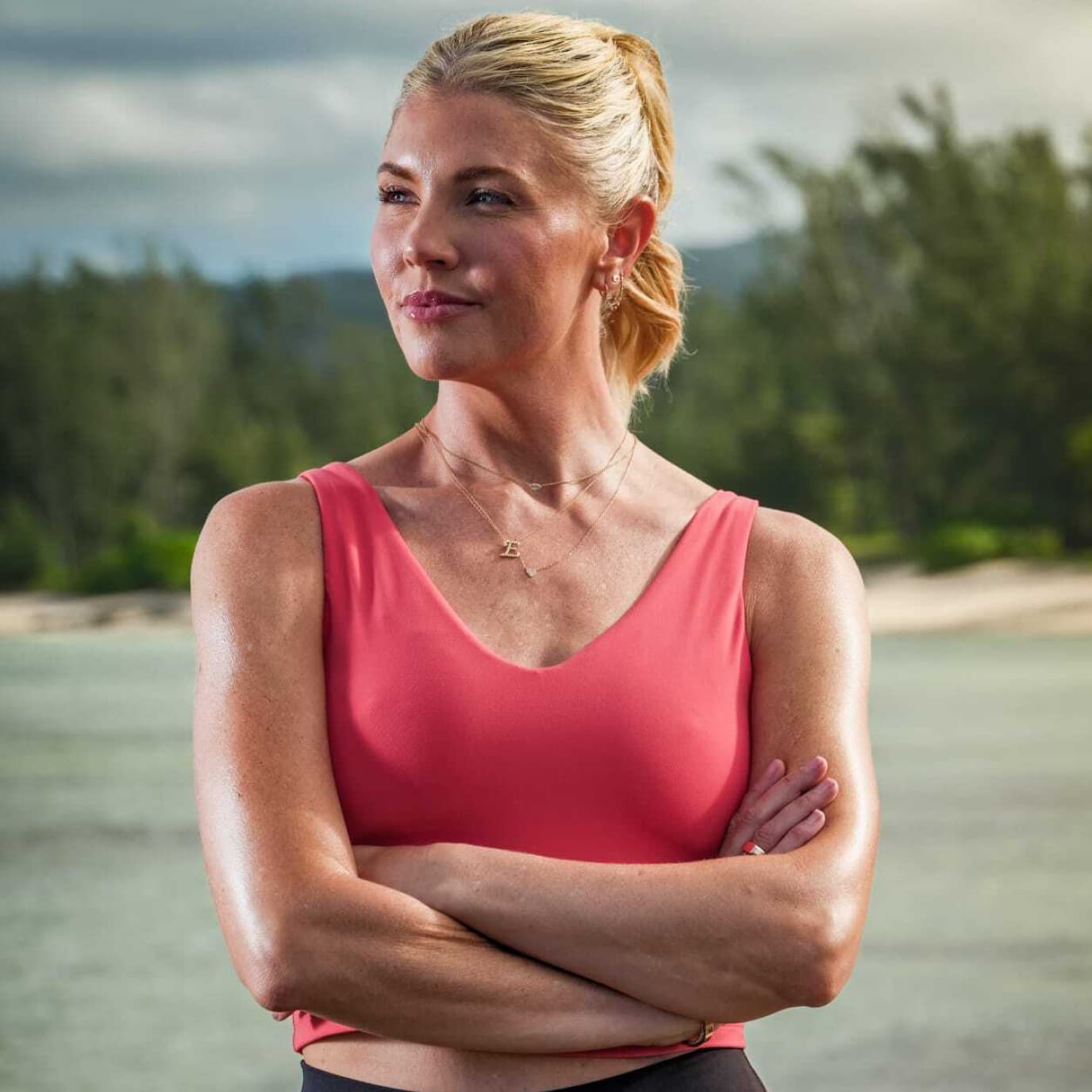 Photo of Host, Amanda Kloots standing by the water on a beach.