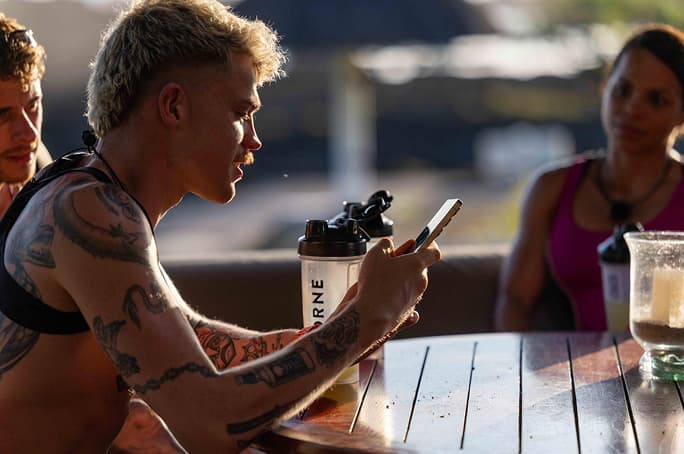 Trainer Games contestant Chris Griffiths sitting at a table next to a Thorne bottle.
