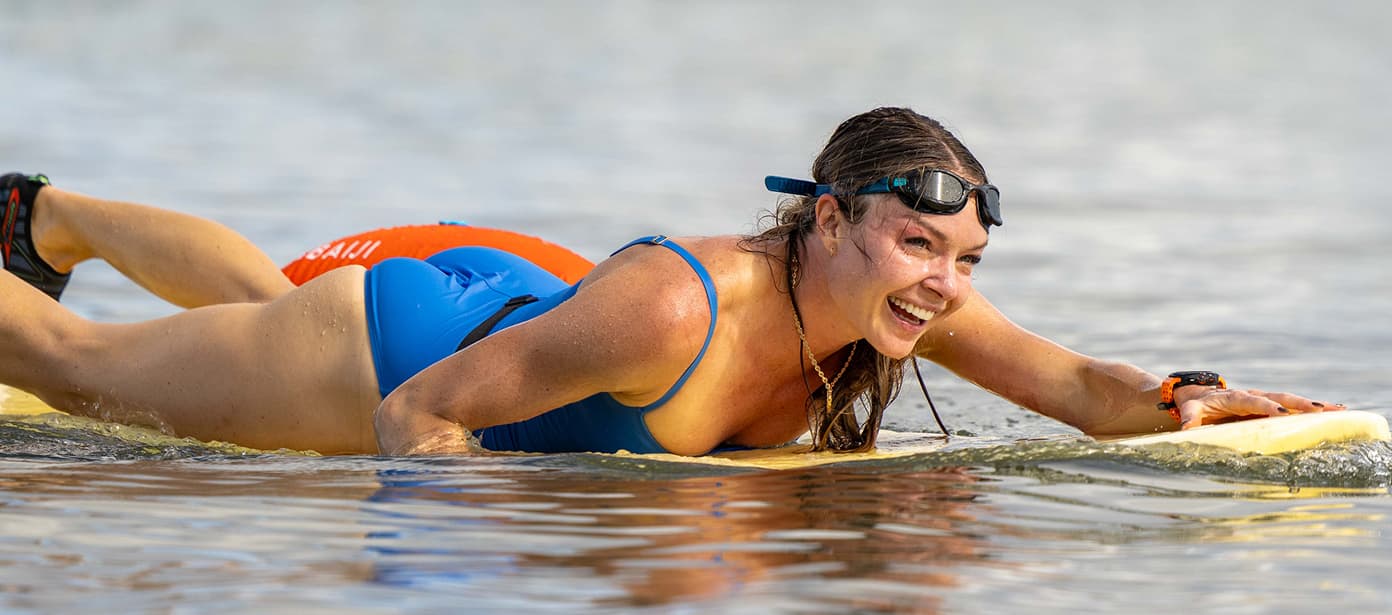 A female competitor paddling on a surfboard wearing a Samsung Galaxy Watch Ultra