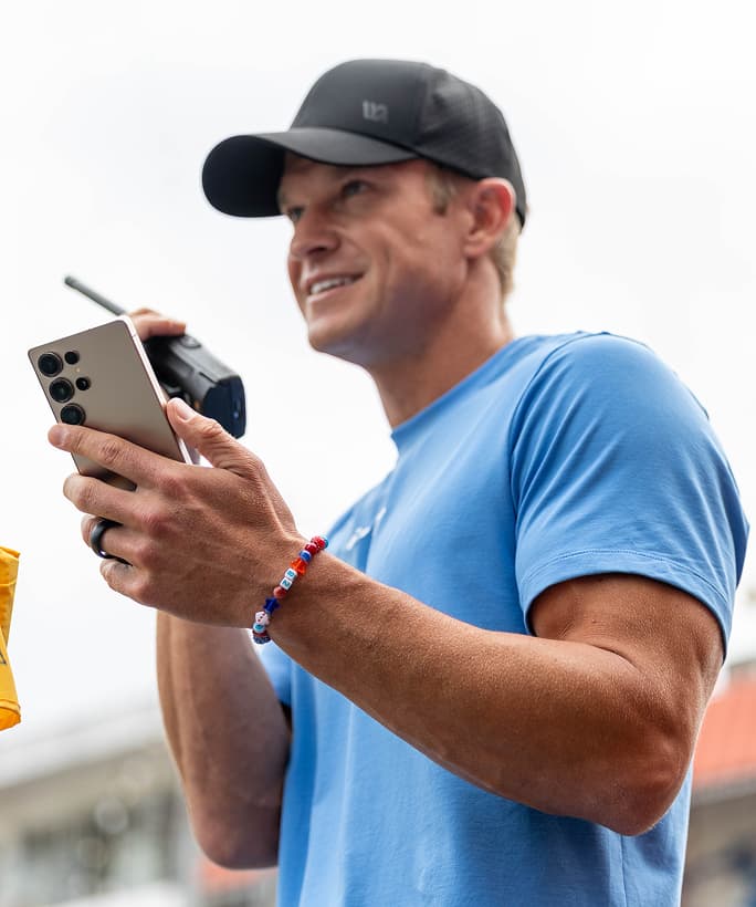 A trainer holding a Samsung S25 Ultra smartphone.