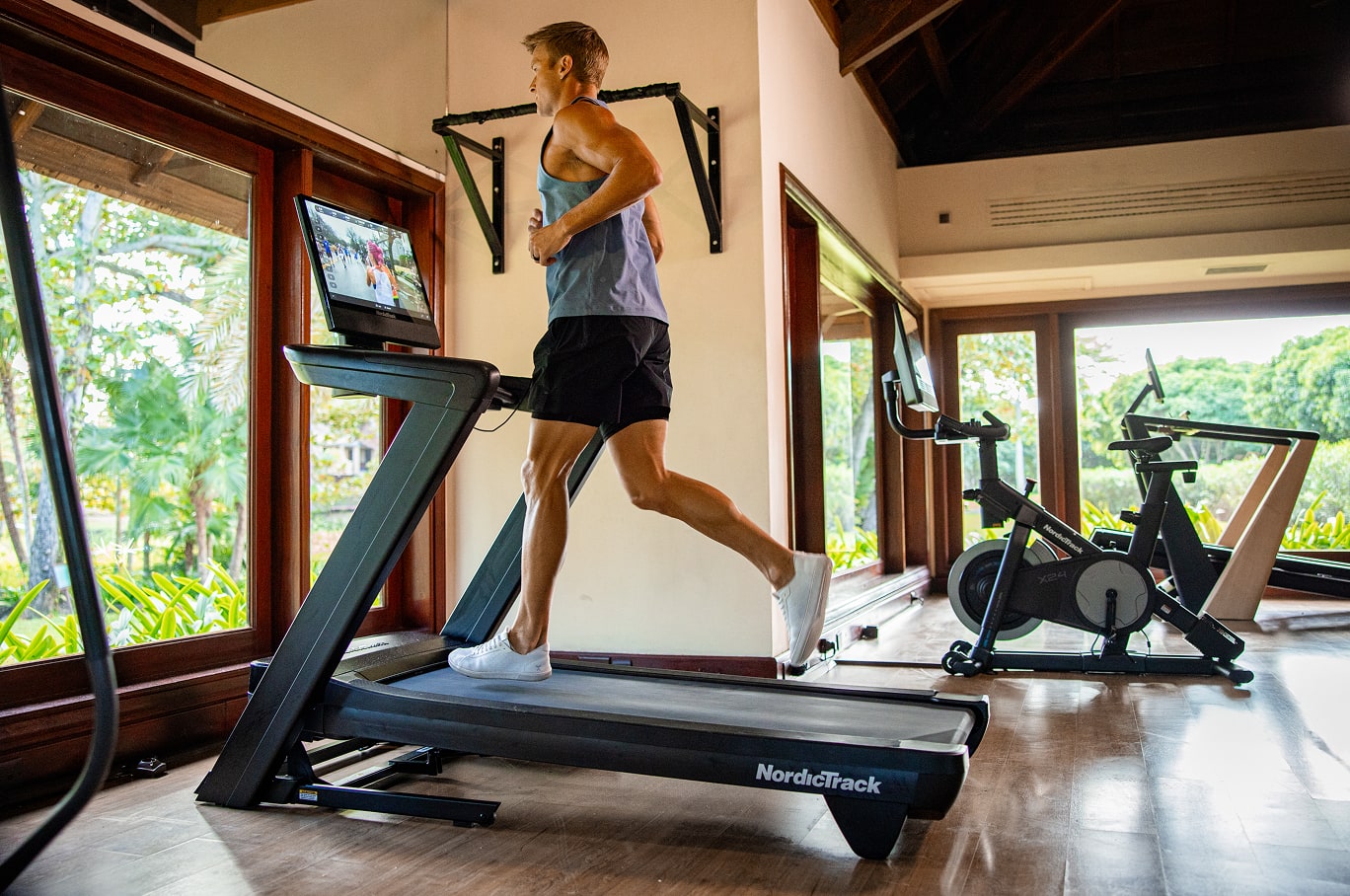 A man running on a NordicTrack treadmill.