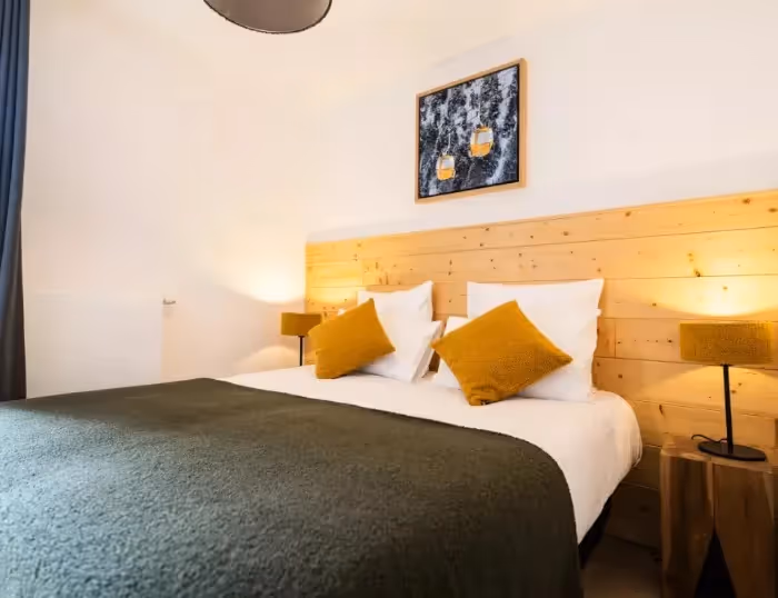 Lit confortable dans un appartement de location 4 étoiles à Combloux avec vue sur le Mont-Blanc.