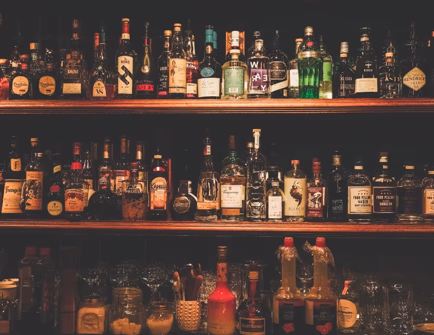 Image of a liquor store shelf filled with various different liquor bottles.