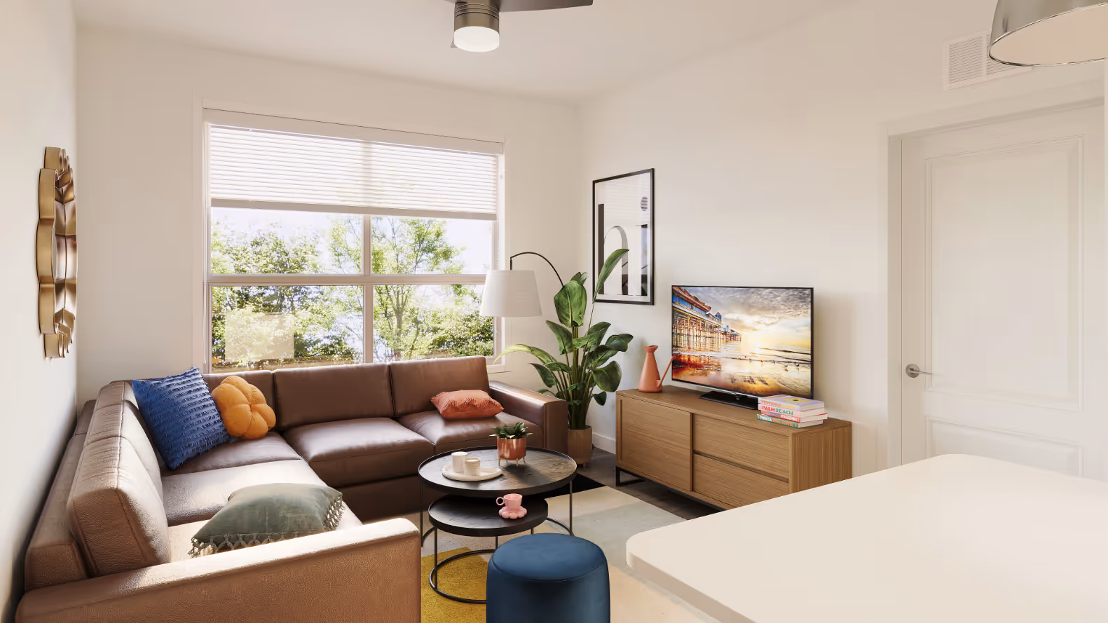 Apartment living room with a brown leather sectional sofa, modern TV console, and a large window with blinds at The Rook in Orlando, FL.