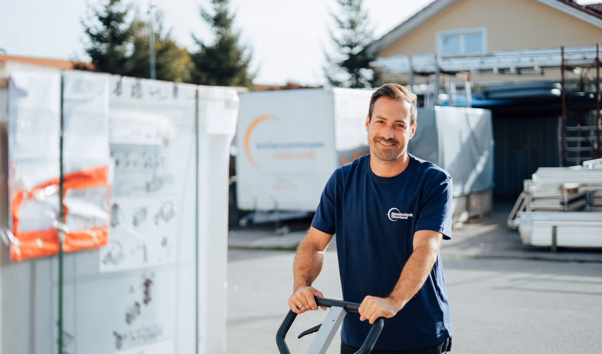 HTO Handwerker mit einem Stapler lächelt in die Kamera