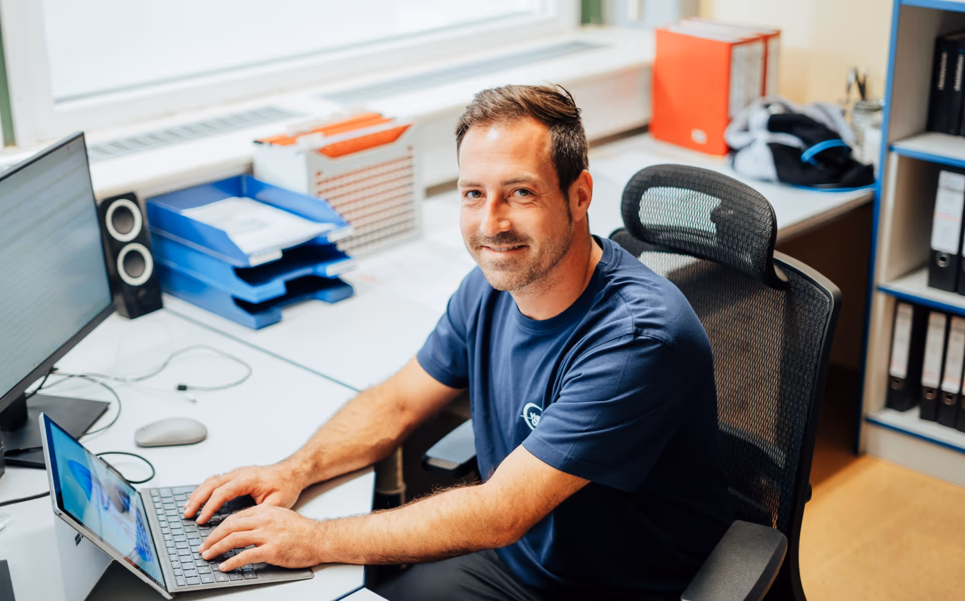 Haustechniker- Oberland Mitarbeiter sitzend im Büro am arbeiten 