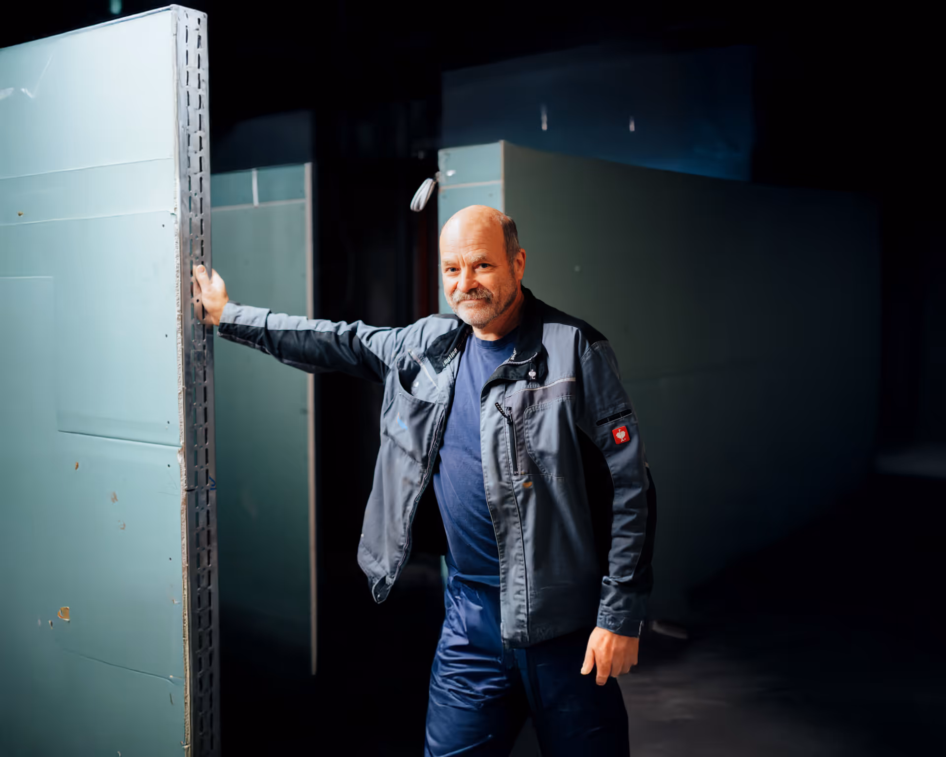 HTO Handwerker steht seitlich mit Hand an Wand gestützt