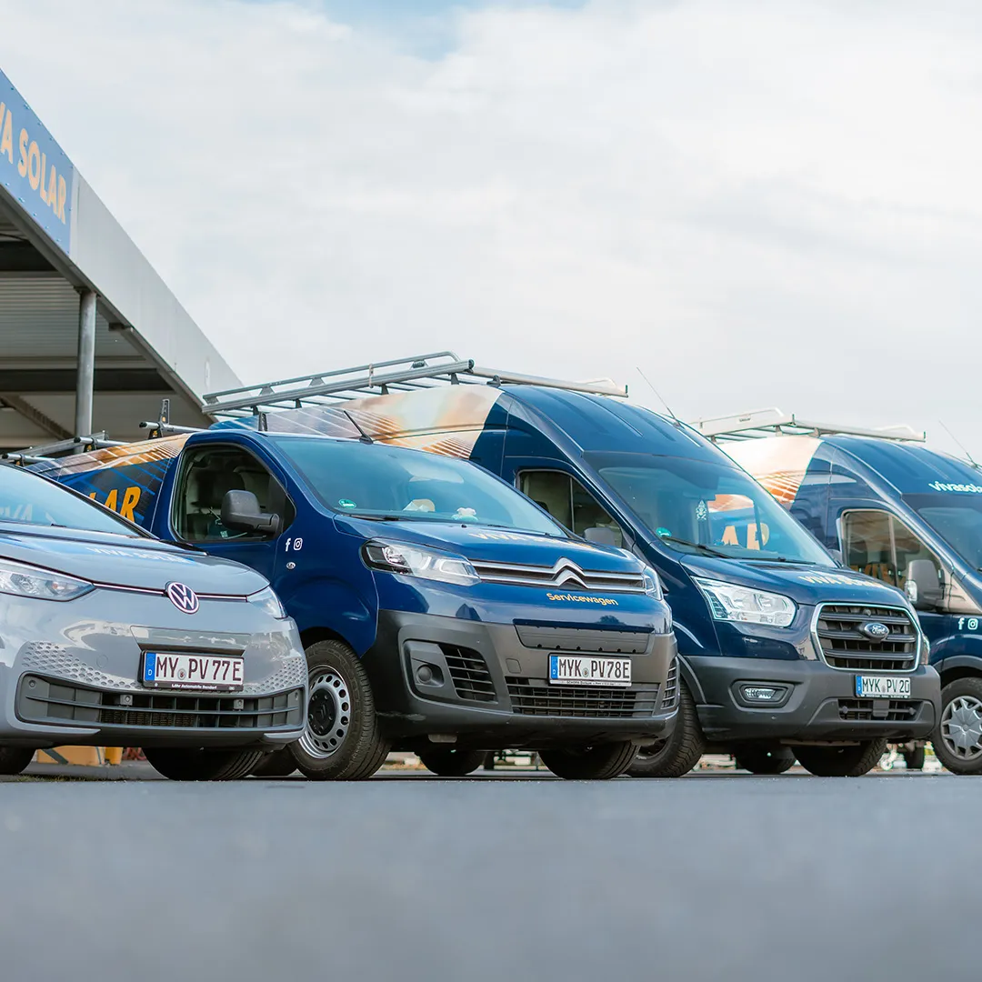 Eine Reihe verschiedener Transporter, darunter Volkswagen, Citroën und Ford, parken unter strahlend blauem Himmel und präsentieren eine moderne Flotte.