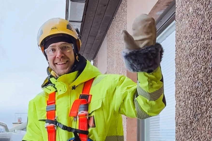 Hymyilevä Nohevan työntekijä tervehtii kameraan