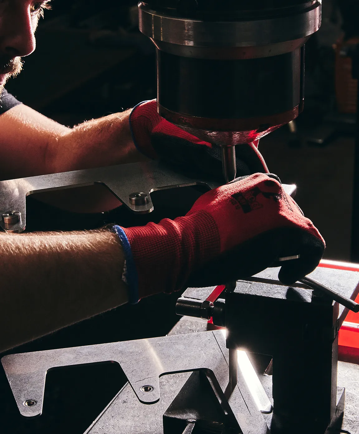 A man working on a machine drilling holes.