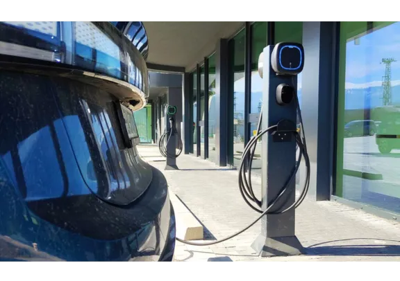 Man charging his car and walking home with his kid