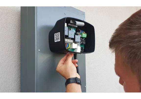 A man fixing a charging stantion